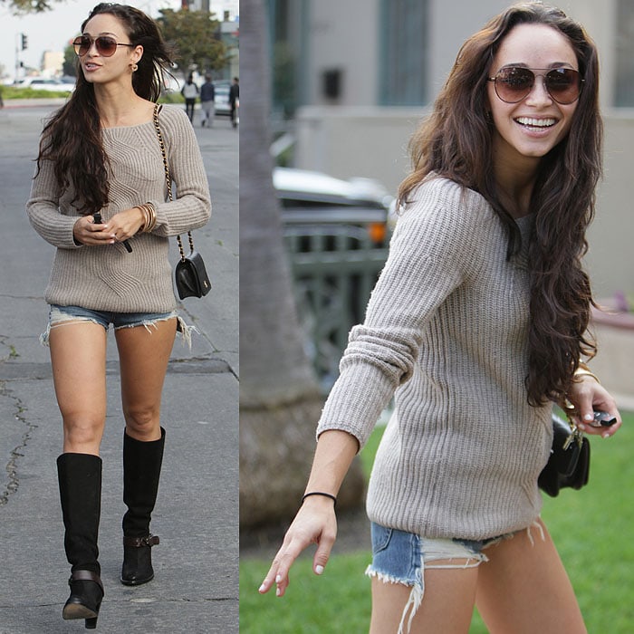 Cara Santana pairs black knee-high boots with ripped daisy duke shorts