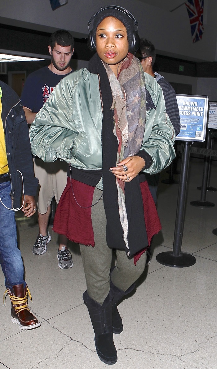 Jennifer Hudson wears several scarves with boots, a beanie, and a thick jacket