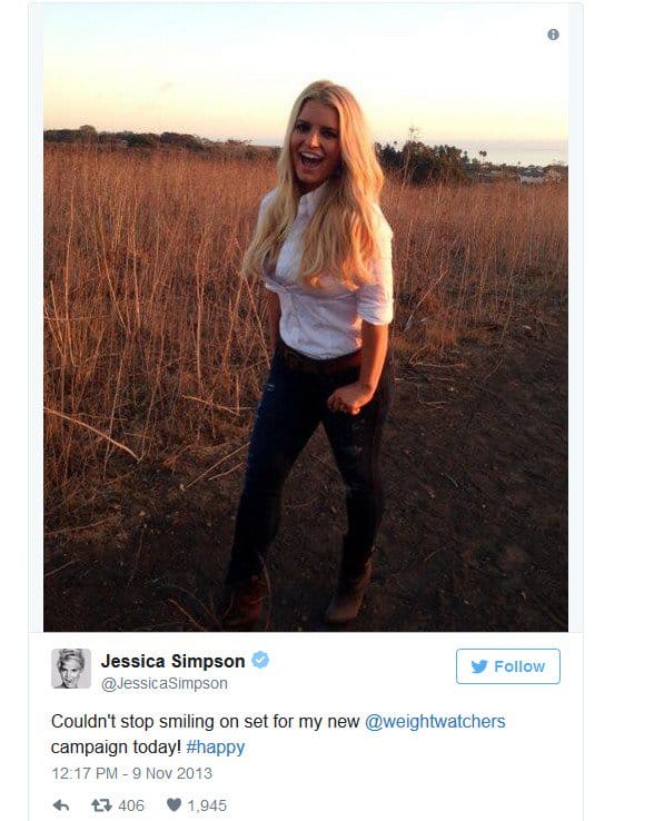 Jessica Simpson showing off her flat stomach in a white button-down shirt