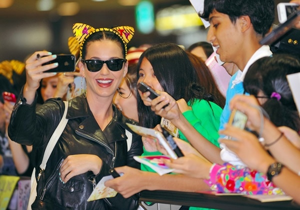 Katy Perry tops her hair with leopard ears and takes selfies with fans