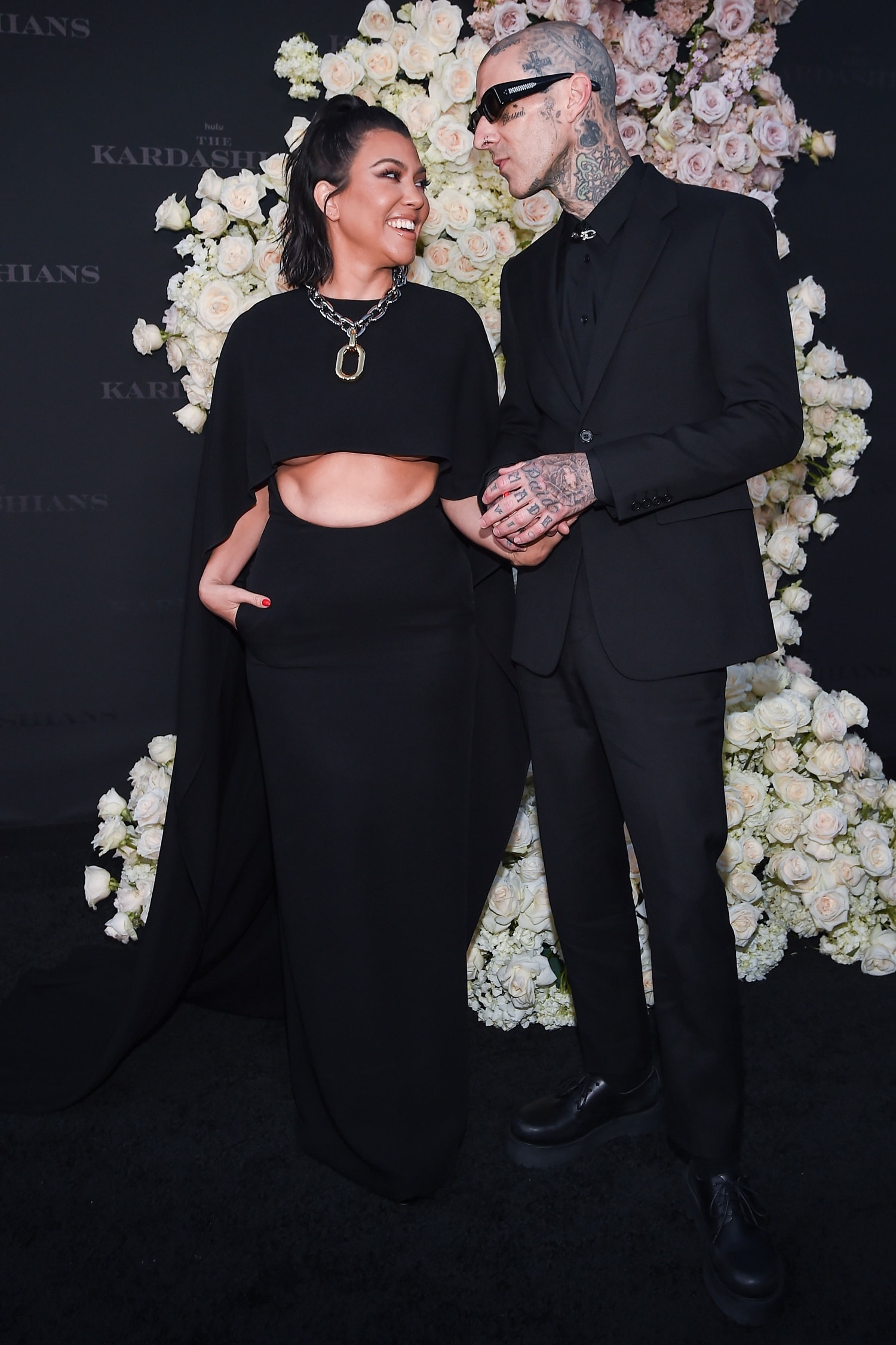 Kourtney Kardashian in a Valentino Fall 2022 cutout dress and Travis Barker at the Los Angeles premiere of Hulu's new show "The Kardashians"
