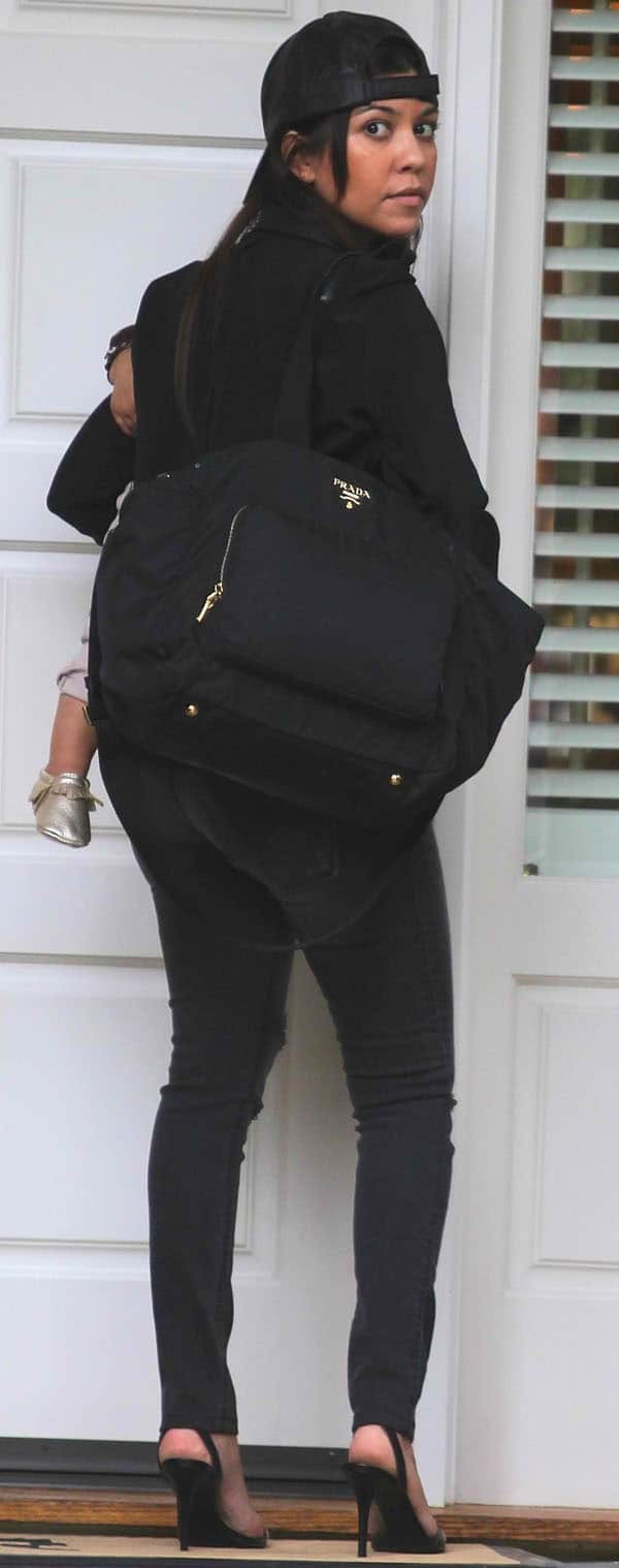 Kourtney Kardashian carries a chic Prada baby bag with her casual outfit
