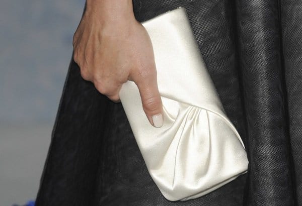 Kristen Bell adds a touch of elegance to her Frozen premiere look with a chic white satin clutch