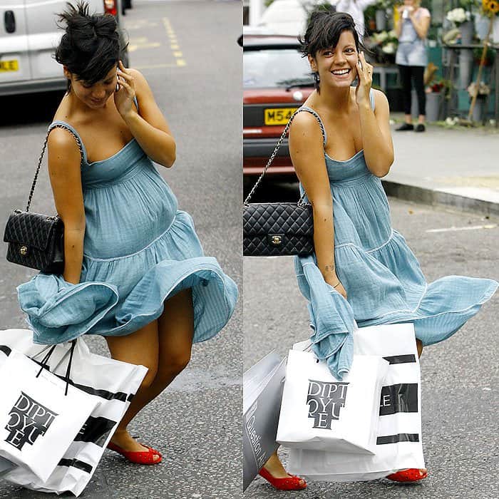 Lily Allen stays cheerful despite a windy shopping trip, playfully managing her flowing blue dress while carrying her bags and sporting a chic Chanel bag