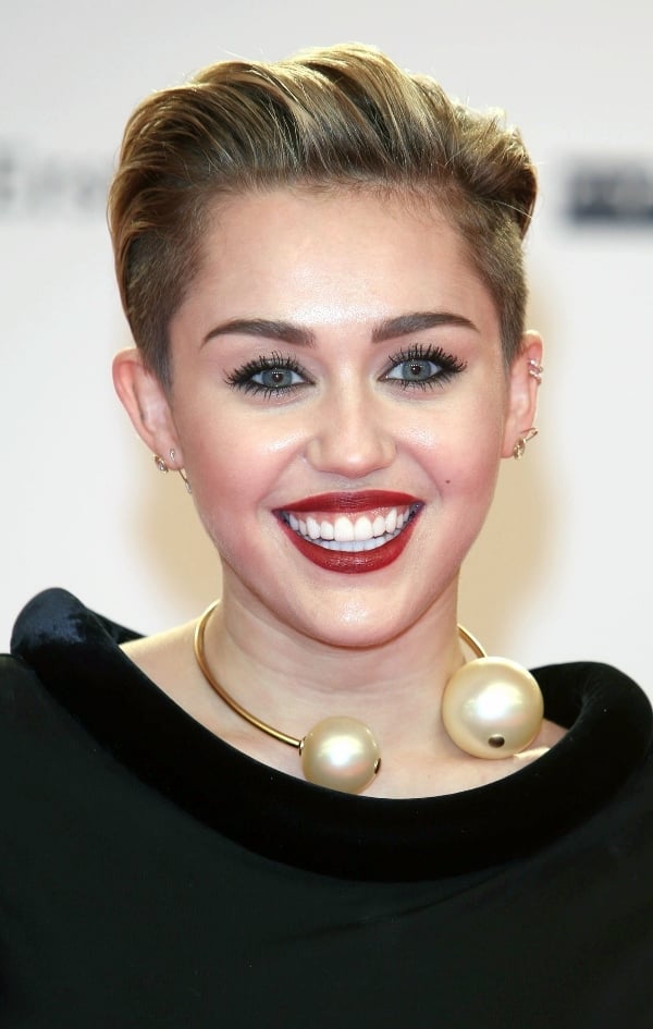 Miley Cyrus accessorized with a dark berry lip and a bold pearl choker