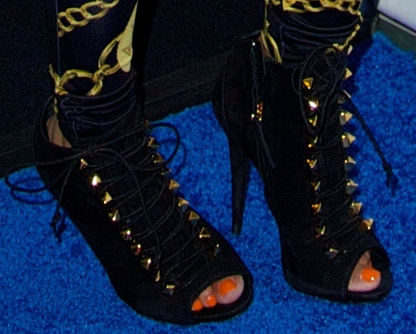 Nicki Minaj completes her bold look with studded Giuseppe Zanotti booties, highlighting her vibrant orange pedicure at Powerhouse 2013