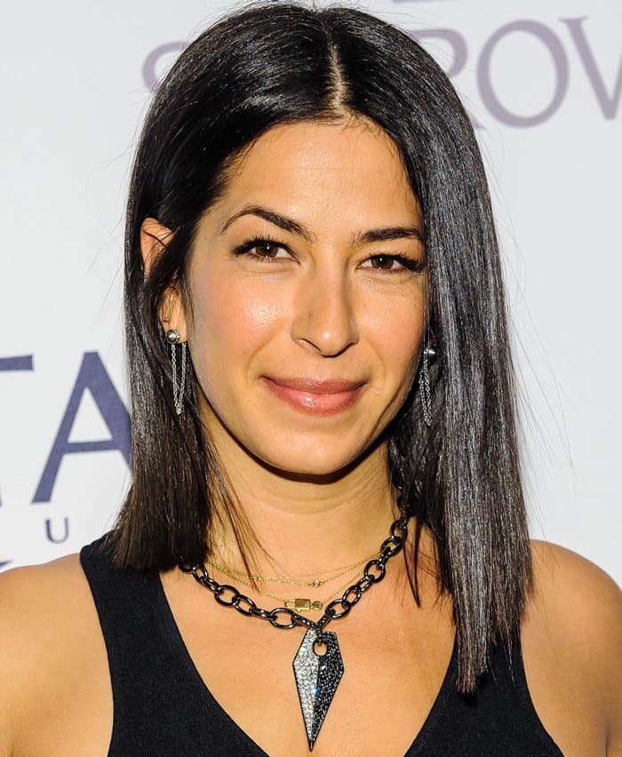 Rebecca Minkoff showcases her sleek, straight hairstyle, subtle makeup, and edgy geometric jewelry