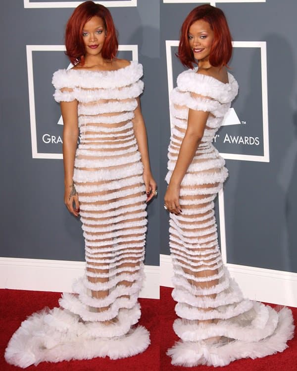Rihanna in a Jean Paul Gaultier couture gown with sheer stripes and voluminous ruffles, complemented by bold red hair and matching lipstick