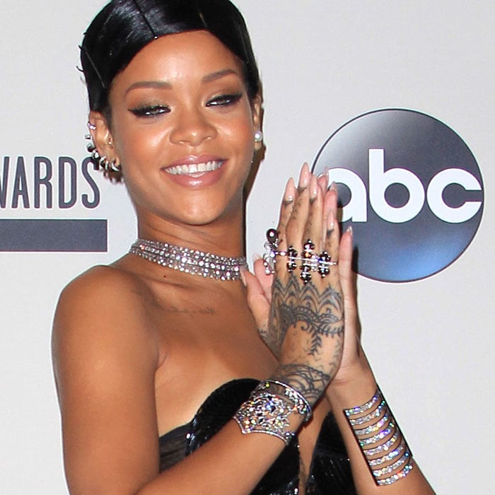 Rihanna displays her diamond jewelry and intricate hand tattoo while attending the 2013 American Music Awards