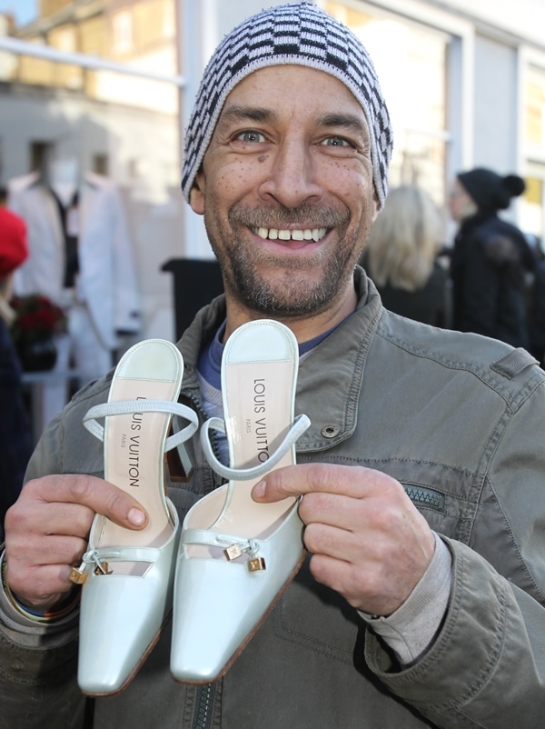 Happy customer holding a pair of Victoria Beckham's donated Louis Vuitton shoes