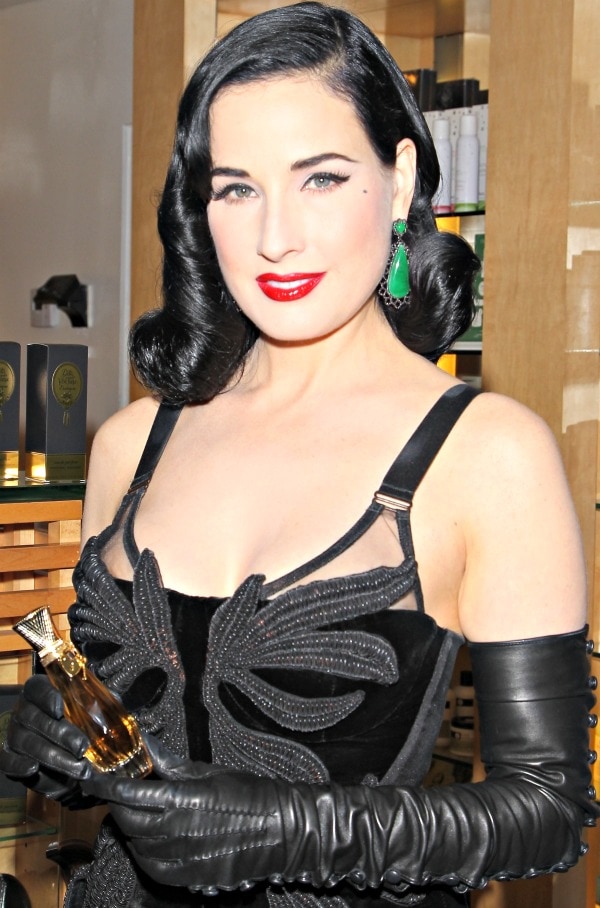 Dita Von Teese carries a bottle of her Erotique Dita Von Teese perfume