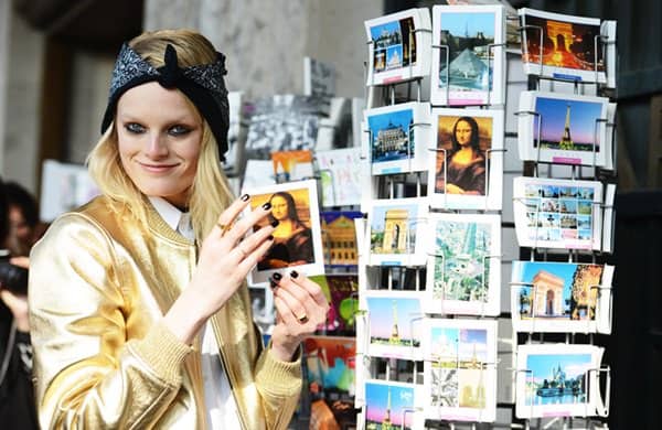 Model Hanne Gaby Odiele checks through some postcards while rocking a metallic jacket and head wrap