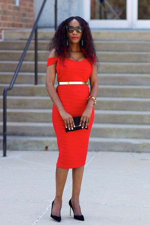 Patie pairs black pumps with a persimmon dress and gold accessories