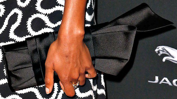 Naomie Harris carries a black clutch with a bow detail