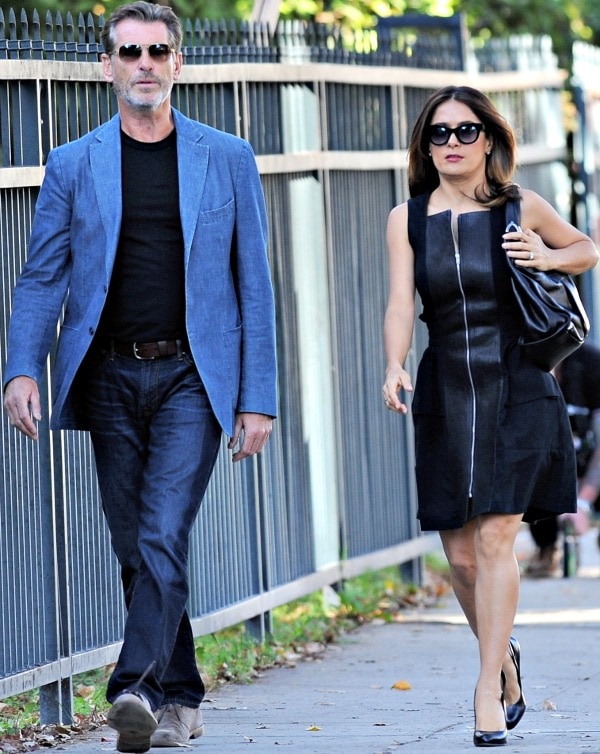 Salma Hayek and Pierce Brosnan walk side-by-side on the set of How to Make Love Like an Englishman, showcasing chic, understated style in October 2013