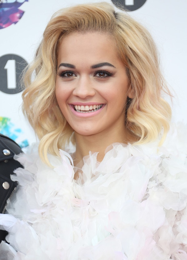 Complementing her ensemble, Rita Ora sported a simple wavy bob and added a touch of color with pale pink lips