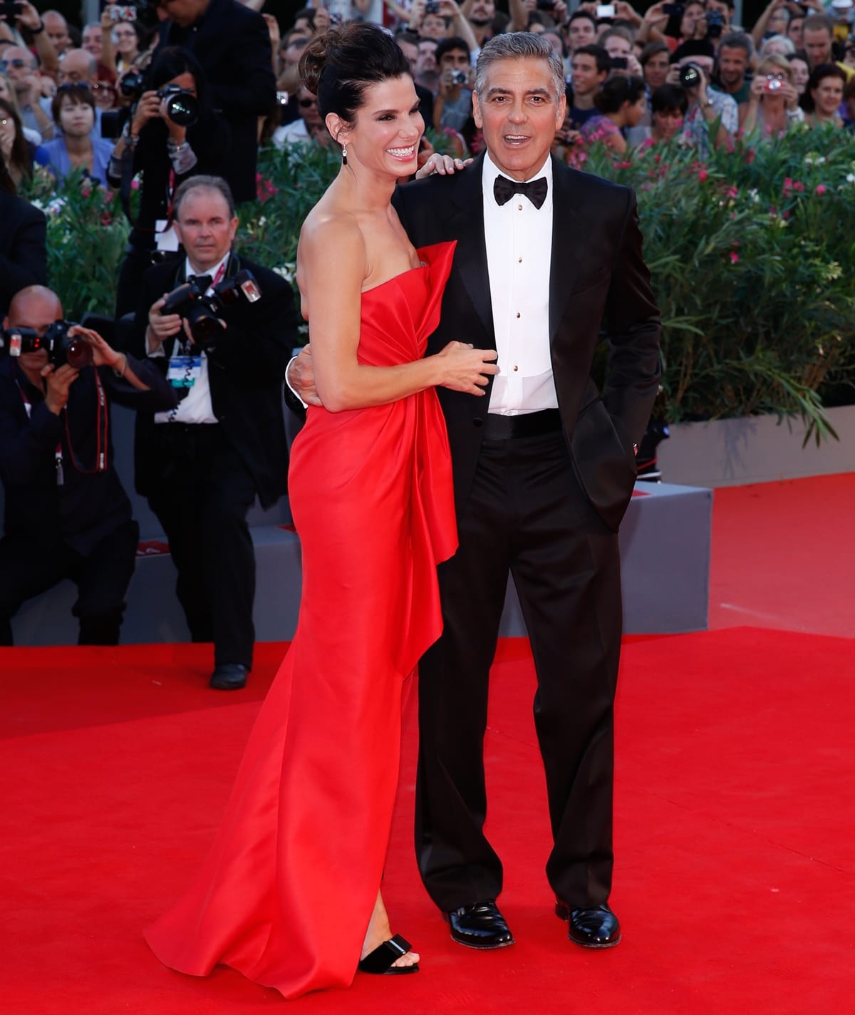 Actor George Clooney and actress Sandra Bullock, in a J. Mendel siren red strapless gown and Roger Vivier shoes, attend the "Gravity" Premiere and Opening Ceremony during the 70th Venice International Film Festival