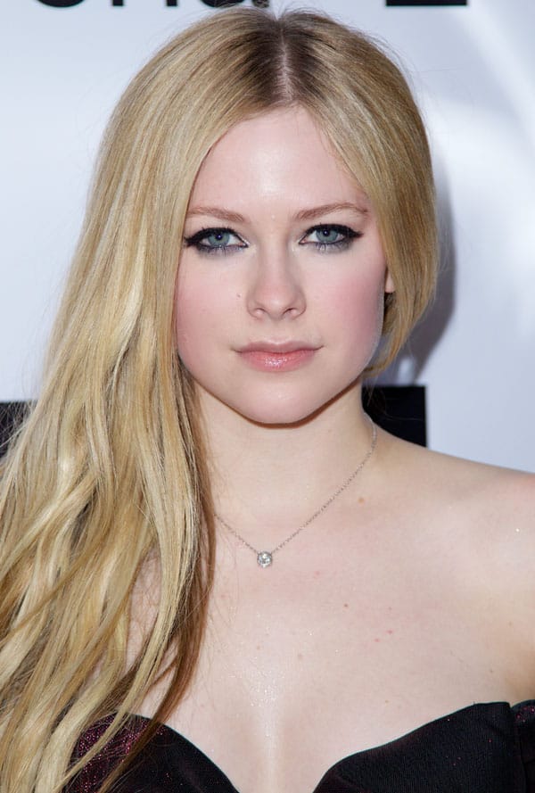 Avril Lavigne exudes elegance with her long, loose waves and flawless makeup, accentuated by a delicate pendant necklace
