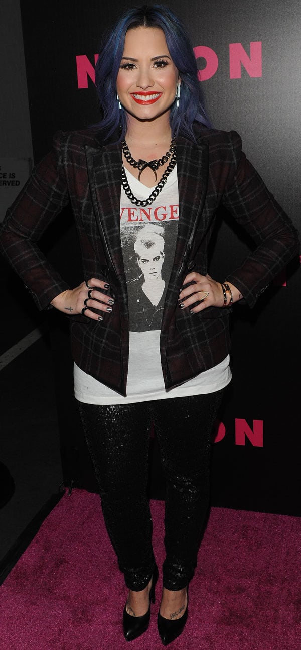 Demi Lovato in sequined black jeans and a plaid jacket, showcasing her edgy style