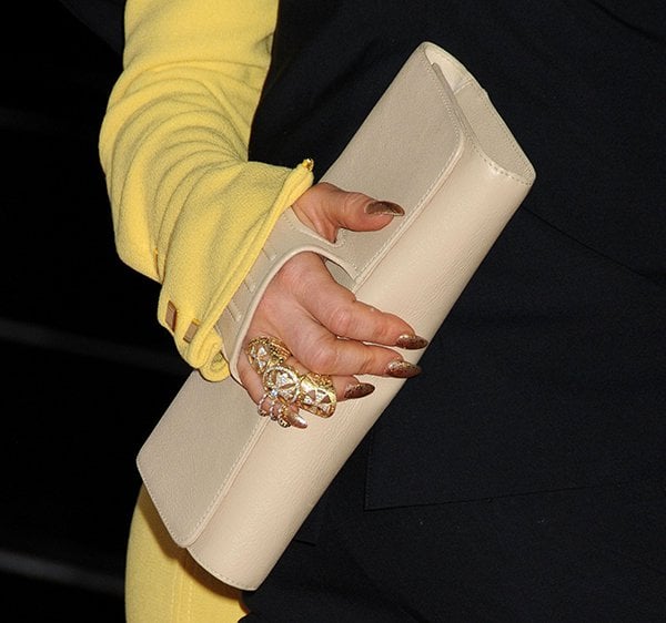 Accentuating her ensemble with a chic touch, Fergie carries the elegant cream-colored Perrin Paris clutch