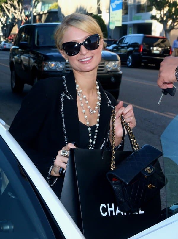 Paris Hilton accessorized with a Chanel pearl necklace and Karen Walker Super Duper Strength sunglasses