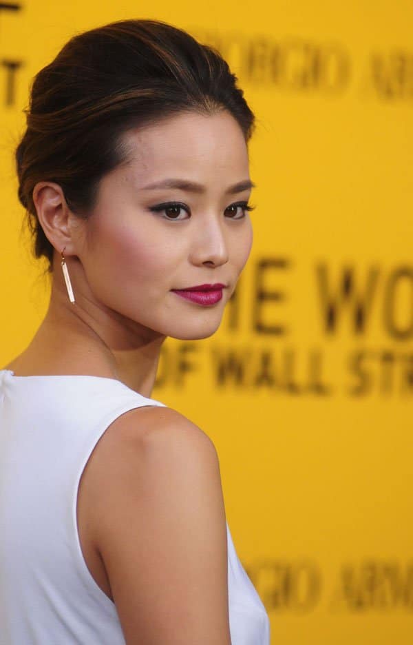Jamie Chung highlighting her elegant earrings and flawless makeup