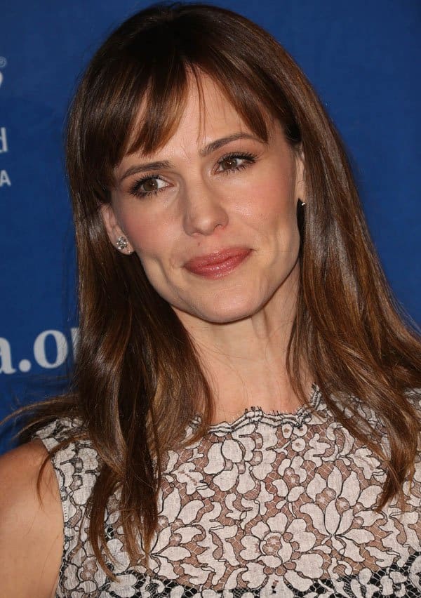 Jennifer Garner's hair styled in loose waves with fun fringes perfectly complements her elegant makeup, creating a youthful and sophisticated look at the Beat the Odds Awards