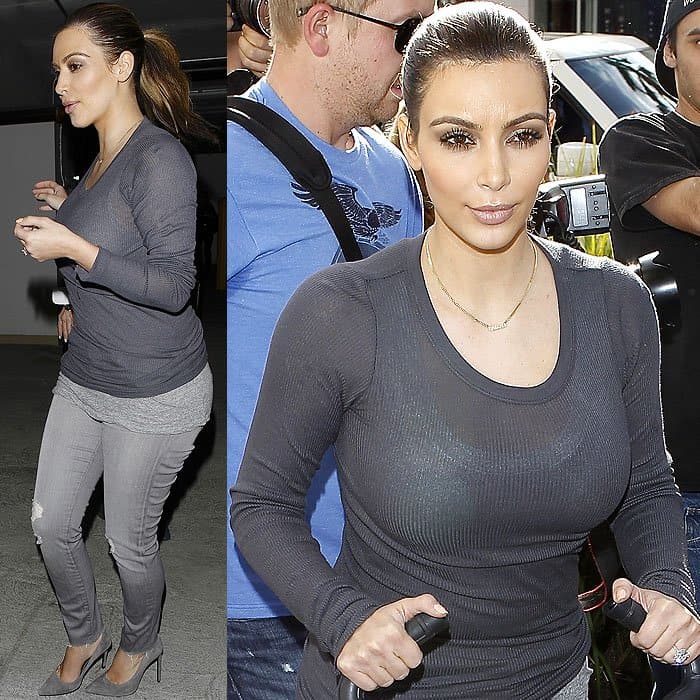 Kim Kardashian stuns in a sophisticated monochrome ensemble, showcasing her impeccable style with a fitted gray ribbed long sleeve t-shirt and matching distressed jeans, complemented perfectly by sleek suede pumps