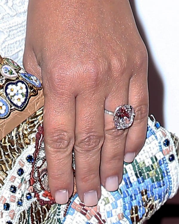 A close-up of Kim Kardashian's breathtaking emerald-cut diamond engagement ring highlights its flawless design and brilliance, making it the centerpiece of her chic ensemble