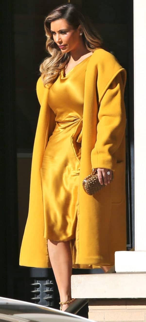 Kim Kardashian dazzles in a gold-toned ensemble with a gold knot clutch from Bottega Venetta