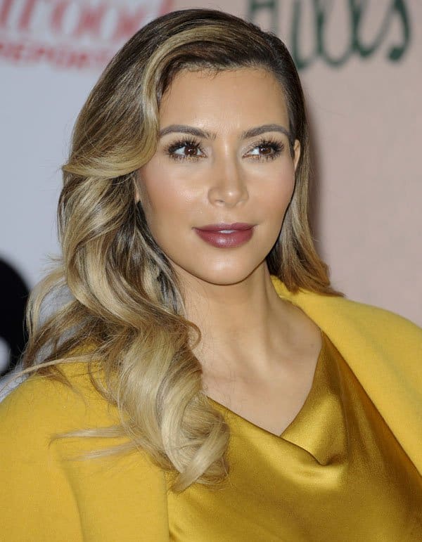 Kim Kardashian showcases her blonde wavy hair, defined lips, and striking eyes at the Hollywood Reporter's Women in Entertainment Breakfast