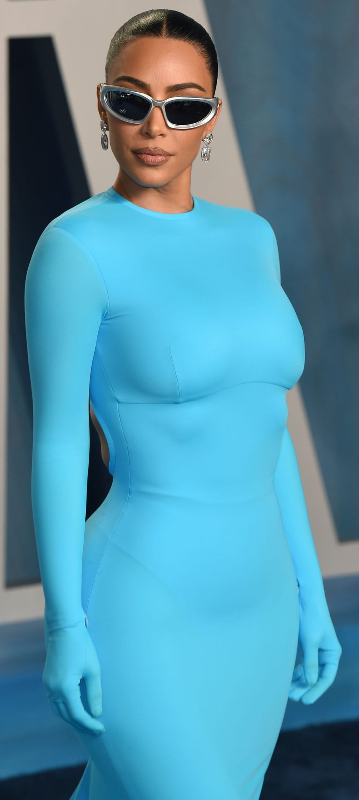 Kim Kardashian pairs her bright blue Balenciaga dress with sunglasses, Lorraine Schwartz diamond earrings, and Skims shapewear