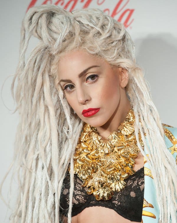 Lady Gaga with bleached dreadlocks, wearing a gold starfish print Versace suit at the 2013 Jingle Bell Ball