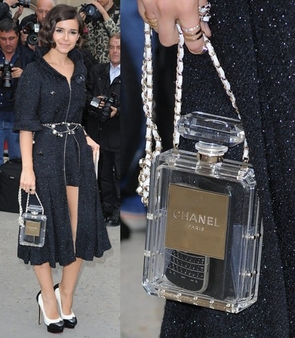 Miroslava Duma dazzles in a glittering navy dress, accessorized with the whimsical Chanel perfume bottle clutch at Chanel's Spring/Summer 2014 runway show in France on October 1, 2013
