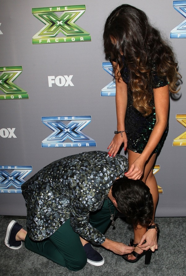 Alex kneeling down to fix and strap one of Sierra's sandals