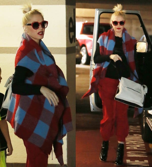Gwen Stefani pairs her red and blue plaid wrap with red pants, a black sweater, red-rimmed sunglasses, and black lace-up booties