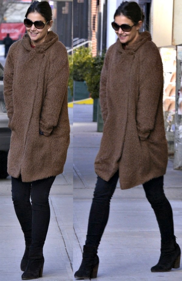 Katie Holmes bundled up in a cozy brown coat, pairing it with dark skinny jeans and black suede Rag & Bone 'Newbury' ankle boots for a chic winter street style in Manhattan