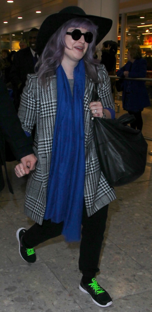 Kelly Osbourne dazzles in a chic ensemble, with a vibrant blue scarf adding a sophisticated touch to her look