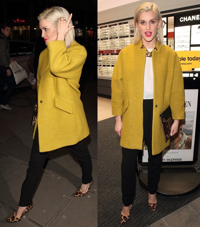 Ashley Roberts pairs a mustard yellow coat with black pants, a white blouse and a statement necklace