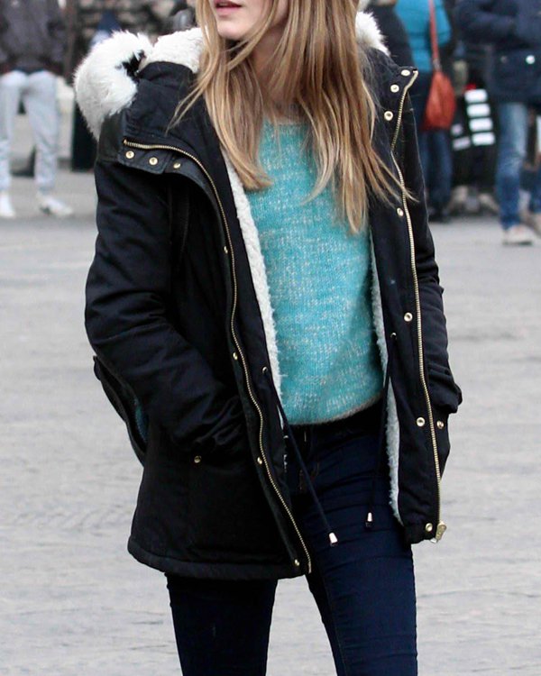 Cara Delevingne layers a Topshop fur trim parka over a teal sweater for a stylish winter look