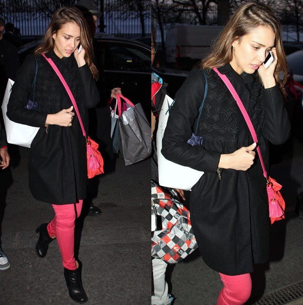 Jessica Alba wearing pink skinny jeans and a black coat while talking on the phone in Paris