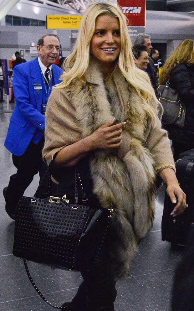 Jessica Simpson wears a faux-fur-trimmed shawl at JFK airport