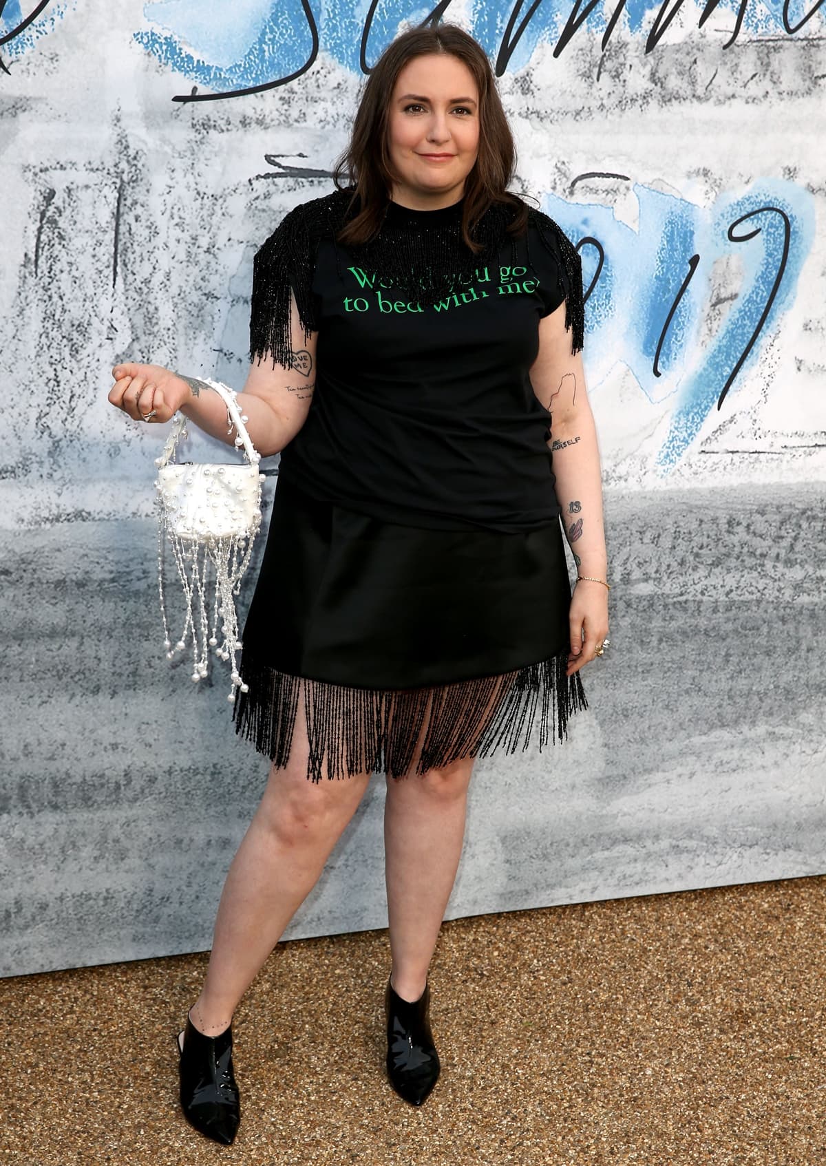 Lena Dunham in a Christopher Kane 'Would you go to be with me?' print fringe-trimmed T-shirt and a fringe skirt