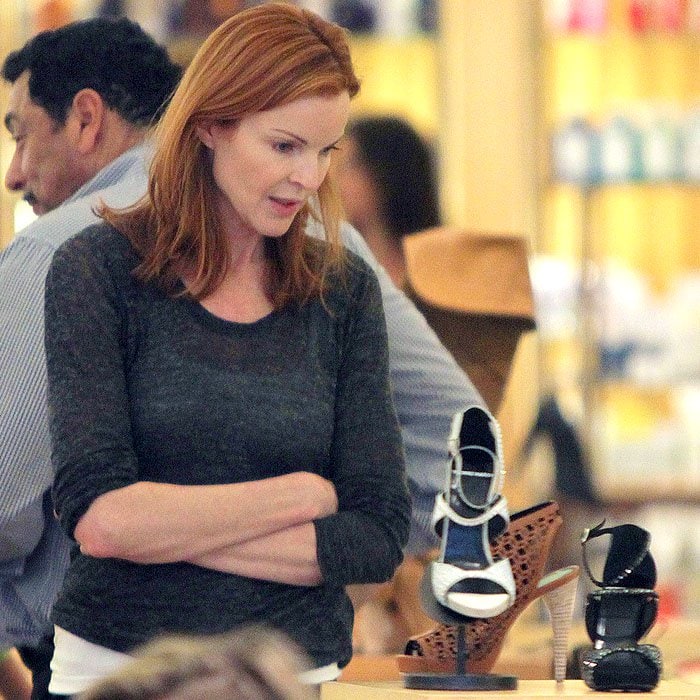 Marcia Cross scrutinizing a shoe on display at Barneys New York in Beverly Hills, California, on March 6, 2010