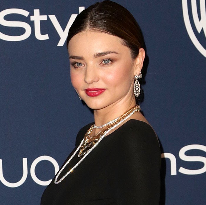 Miranda Kerr shows off her feather earrings at a Golden Globes Awards after party