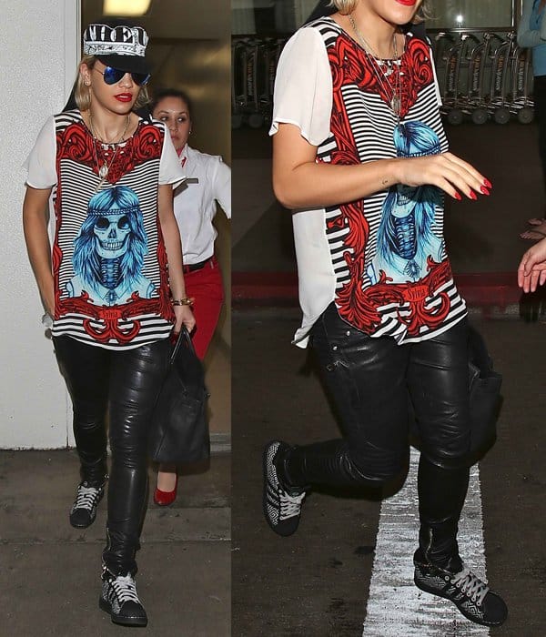 Rita Ora rocks a casual-chic airport look with a loose-fitting sweater, sneakers, and a fedora hat