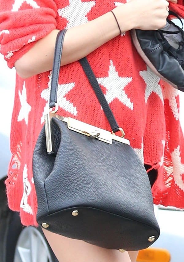 Taylor Swift totes a shoulder bag with golden hardware