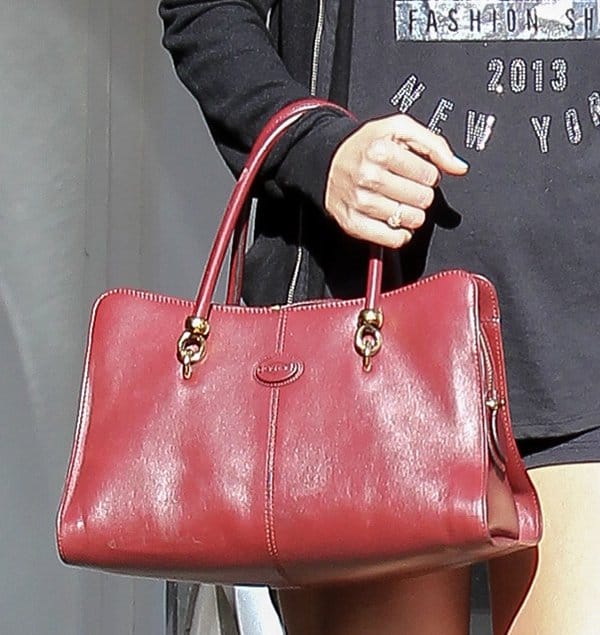 Taylor Swift's strawberry red leather tote bag from Tod's exudes elegance and sophistication, featuring gold-tone hardware and a sleek design