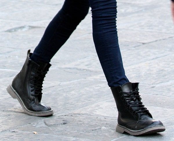 Cara Delevingne wears bulky black boots while filming "The Face of an Angel"