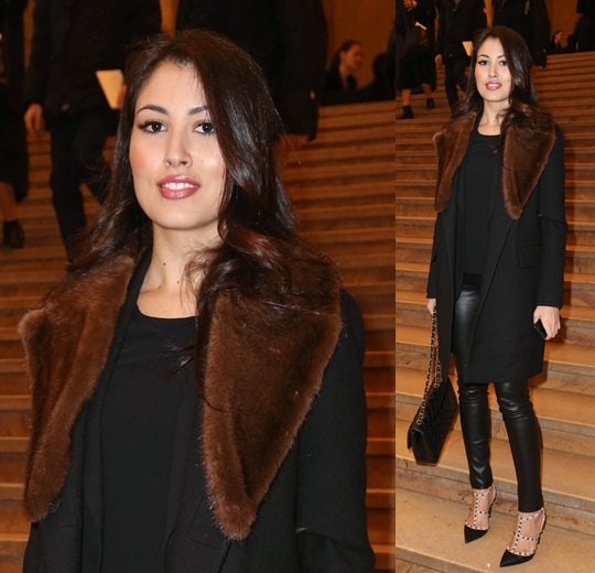 Yasmine Tordjman exudes sophistication in a fur-collared black coat, leather skinnies, and iconic Valentino Rockstud pumps at the Stephane Rolland show during Paris Fashion Week